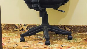 A black office chair with a desk and a laptop.