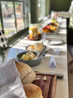 Un buffet de petit-déjeuner proposant divers aliments, ainsi qu’une planche à découper en bois avec des biscuits.