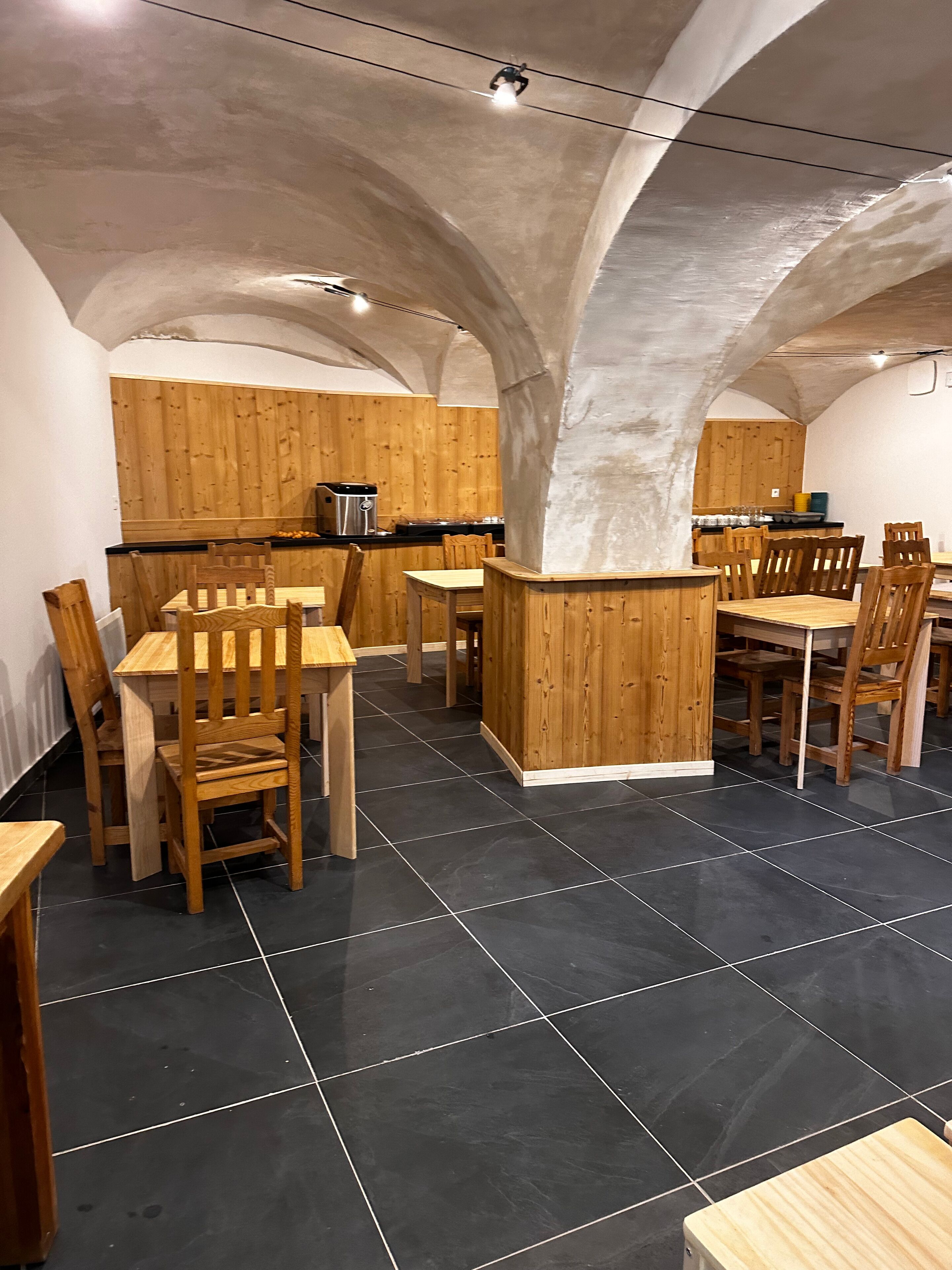 A restaurant with wooden furniture and a tiled floor.