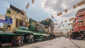 A street with shops and a large billboard advertising a hotel.
