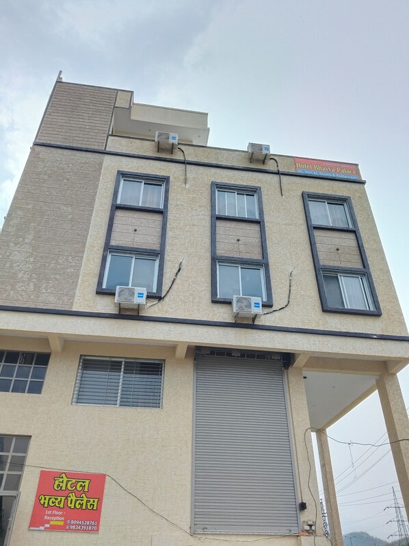 A multi-story building with a sign for Hotel Bhayya Palace, indicating it has AC and non-AC rooms and a restaurant. - Hotel Bhavya Palace (Udaipur)