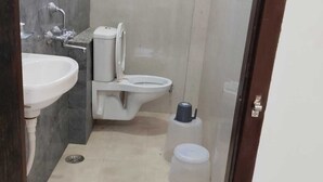 A bathroom with a sink, toilet, and shower. - Hotel Bhavya Palace (Udaipur)
