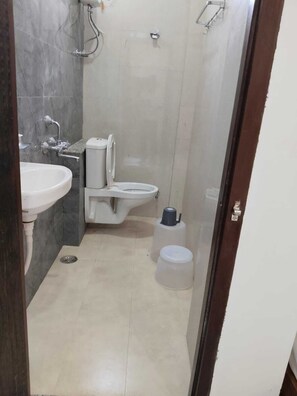 A bathroom with a sink, toilet, and shower. - Hotel Bhavya Palace (Udaipur)