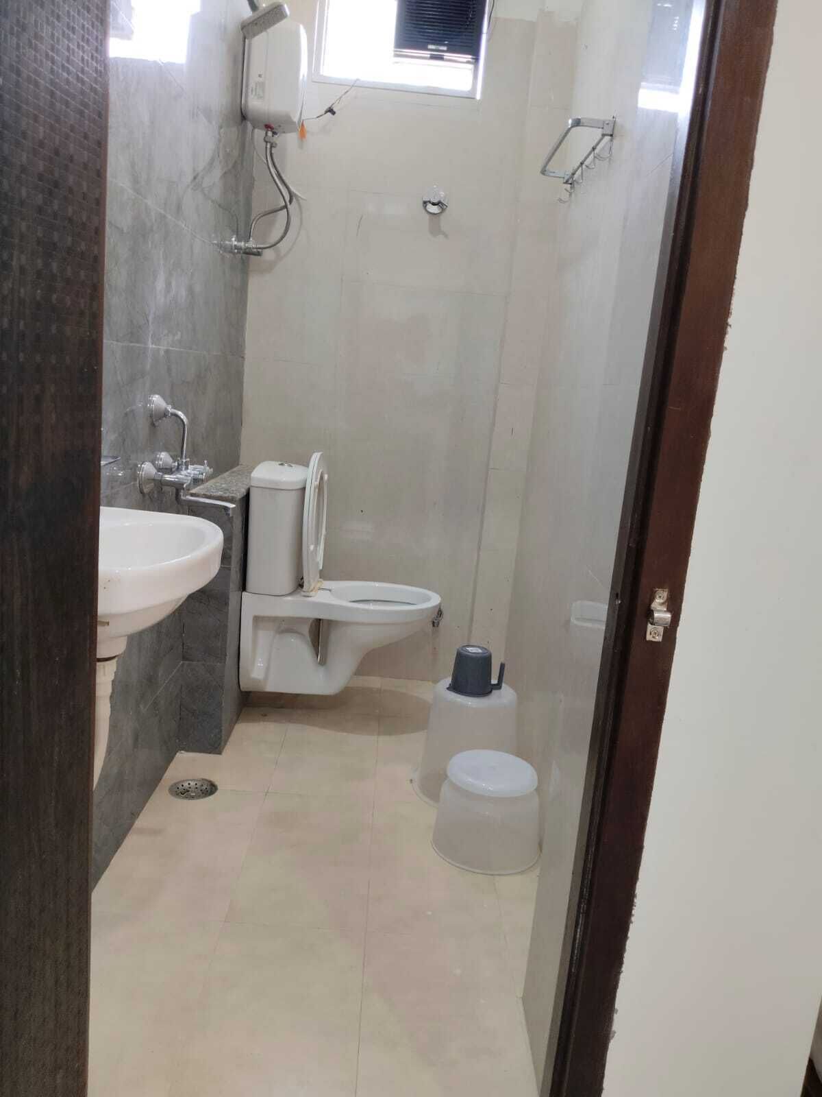 Un bany petit amb un lavabo, vàter i plat de dutxa.