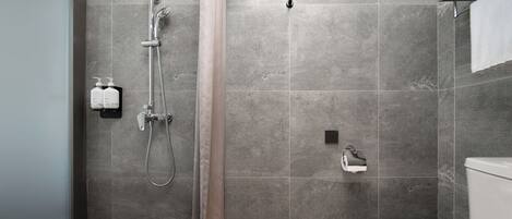 Een moderne badkamer met douche, toilet en handdoekrek.