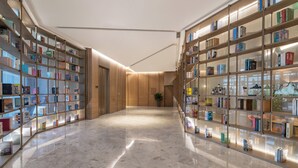 Eine moderne Bibliothek mit Bücherregalen auf einem polierten Marmorboden.