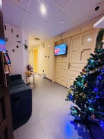 A reception area with a Christmas tree, a television, and a seating area.