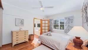 Une chambre à coucher avec un lit, une commode et un ventilateur de plafond.