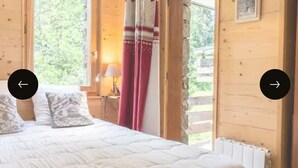 Una habitación con piso de madera, una cama, un ventanal y un radiador.
