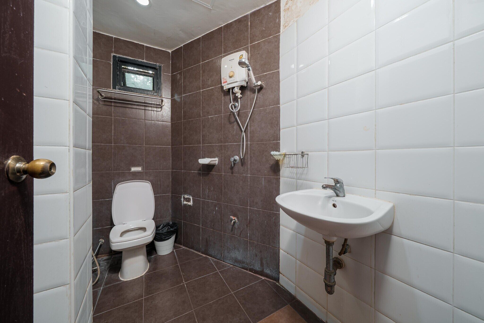 A bathroom with a toilet, shower, and sink.