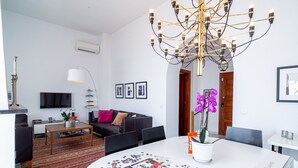A modern living room with a round table, a sofa, a coffee table, and a chandelier. - Villa Prime Seaview by Casasol (Nerja)