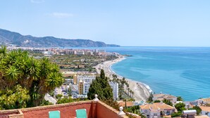 A coastal cityscape with a beach, buildings, and palm trees. - Villa Prime Seaview by Casasol (Nerja)