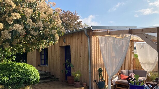 A wooden deck with a covered seating area, potted plants, and a pergola with a white canopy. - Charming house 3 kms from Caen.  Comfort, light, location -> Coup de coeur! (Fleury-sur-Orne)
