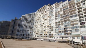 A modern high-rise residential building with multiple balconies and a flat rooftop terrace. - Studio in Empuriabrava with Sea Views (Empuriabrava)