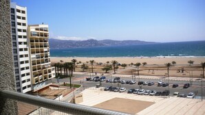 A view of a beach with a parking lot and a building with multiple floors. - Studio in Empuriabrava with Sea Views (Empuriabrava)