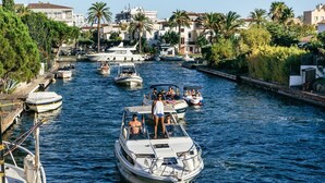 A marina with boats docked along a canal, surrounded by residential buildings and greenery. - Studio in Empuriabrava with Sea Views (Empuriabrava)