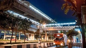 Une structure urbaine à plusieurs niveaux, dotée d’un pont piétonnier et d’un bus en mouvement.