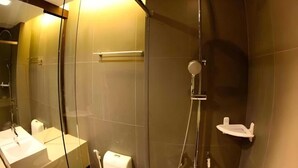 Une salle de bain moderne avec une douche à parois de verre, un lavabo blanc et un porte-serviettes.