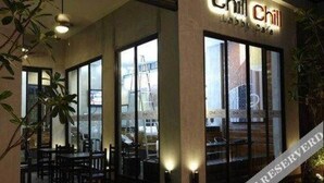 Un restaurant appelé « Chill Chill », doté d’un intérieur moderne, de grandes fenêtres et d’une terrasse.