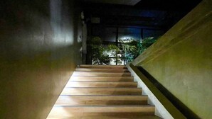 Un escalier avec des marches en bois menant vers le haut, entouré de murs.