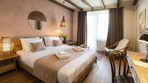 A well-lit bedroom with a large bed, bedside lamps, a chair, and a desk. - Hameau Mukhrani (Mtskheta)
