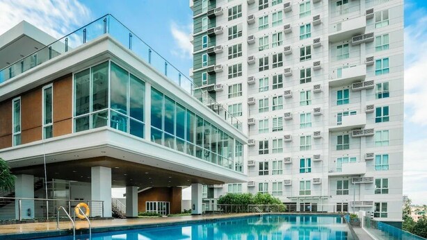 A modern building with a swimming pool, large windows, and a flat roof. - Davao Central Suites (Davao City)