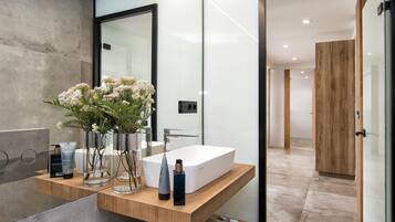 Een moderne badkamer met een grote spiegel, een wit wastafelmeubel en houten planken.