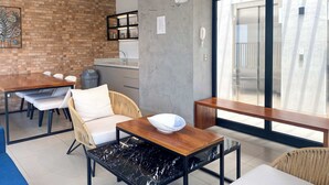 A modern living space with a dining area, kitchen, and a large sliding glass door leading to a balcony. - w* | Well-Located 2BR in Miraflores (Miraflores)