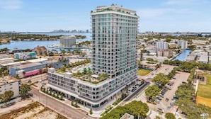 Un hôtel de grande hauteur, avec de nombreux étages, un jardin sur le toit et une vue sur le paysage urbain et les étendues d’eau environnantes.
