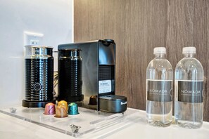 A coffee machine, two water bottles, and a coffee grinder on a countertop.