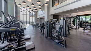 Ett gym med löpband, styrketräningsmaskiner och träningsbänkar.
