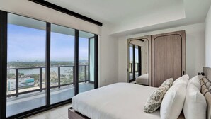 Una camera da letto con un grande letto, vista sulla città e un balcone.