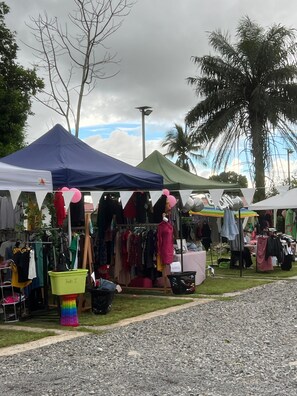 A market stall with various clothing items and a rainbow-colored stool. - Hotel Crown Mirage (David Sur)