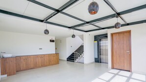 A spacious, well-lit interior with a kitchen area, a staircase, and a door leading to another room. - Royal Mark (Bengaluru)