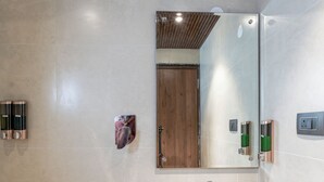 A modern bathroom with a large mirror, a white sink, and a showerhead. - Royal Mark (Bengaluru)