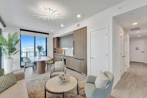 Un appartement moderne comprenant un coin repas, une cuisine et un salon.
