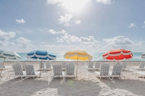 A beach with rows of beach chairs and umbrellas.