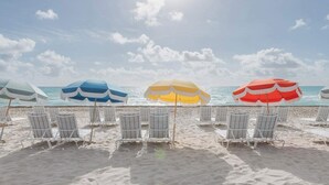 A beach with rows of beach chairs and umbrellas. - 20th Floor Luxe Escape | Pool, Gym & Beach Access (Miami Beach)