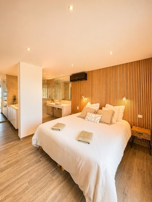 Une chambre moderne avec un grand lit, une salle de bain et un coin cuisine.
