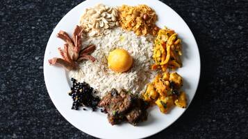 A plate of food with rice, a boiled egg, and various side dishes.