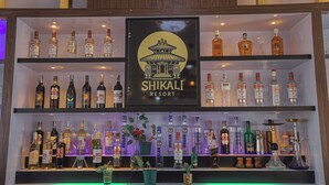 A bar with various liquor bottles and a sign for Shikali Resort. - Shikali Resort (Khokana)