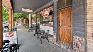 A café with outdoor seating, a wooden door, and a menu board advertising crepes and espresso. - Walk to Shopping | 15 Mins to the Resort (Whitefish)