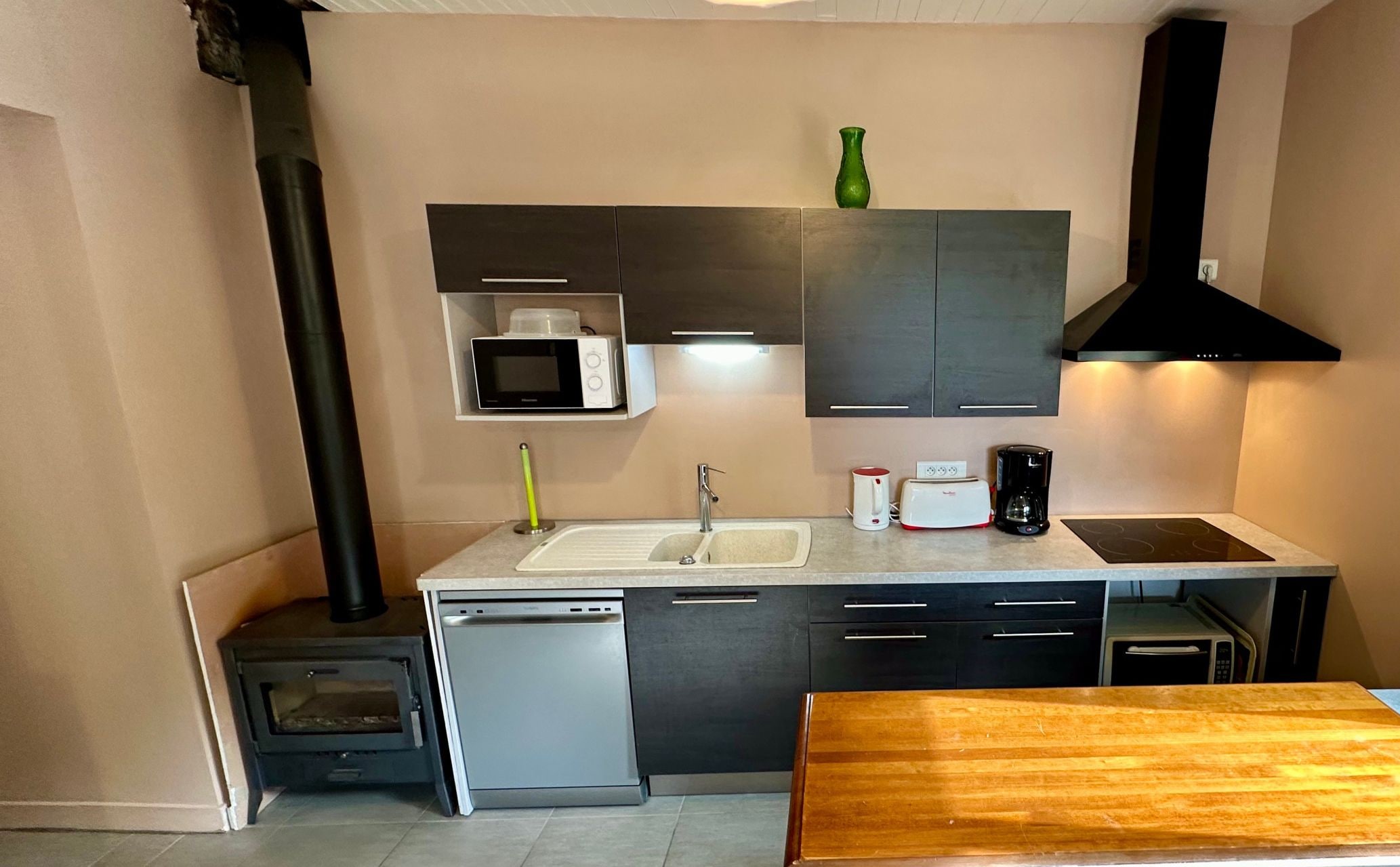 Una cocina compacta equipada con microondas, tostadora, cafetera y estufa.