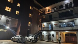 A multi-story building with a car parked in front. - Jinna suites limited (Seeta)