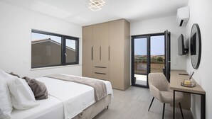 A modern bedroom with a bed, a desk, and a chair. There is a sliding door leading to a balcony. - Villa del Sol near Fažana (Valbandon)