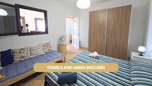 A bedroom with a bed, a sofa, a wardrobe, and a mirror. - Dammuso - Cala Cinque Denti - AFFITTI\'CA (Pantelleria)