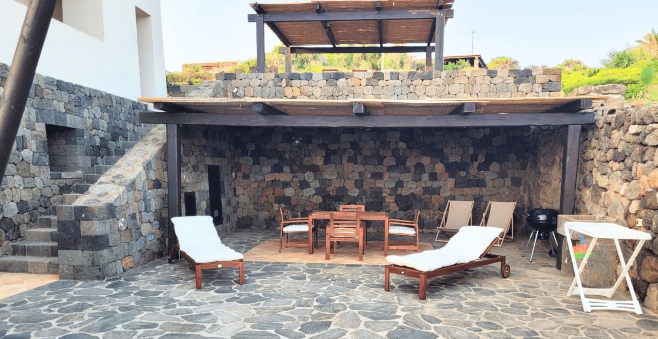 A private terrace with stone flooring, a barbecue area, and outdoor seating.