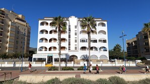 A multi-story building with balconies, palm trees, and a clear blue sky. - Front line, sea view, wifi, parking (Unknown)