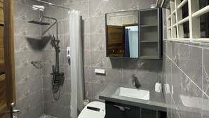 A modern bathroom with a shower, toilet, and sink. - Villa Fafa — Comfort in style (Ho)
