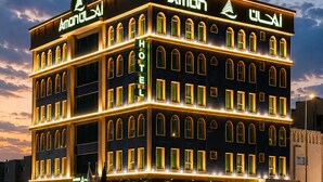 Een hotel met meerdere verdiepingen, een opvallend bord, veel ramen en een goed verlichte gevel.
